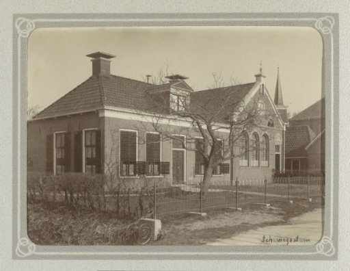 House and school building in Scharnegoutum, with a church tower in the background