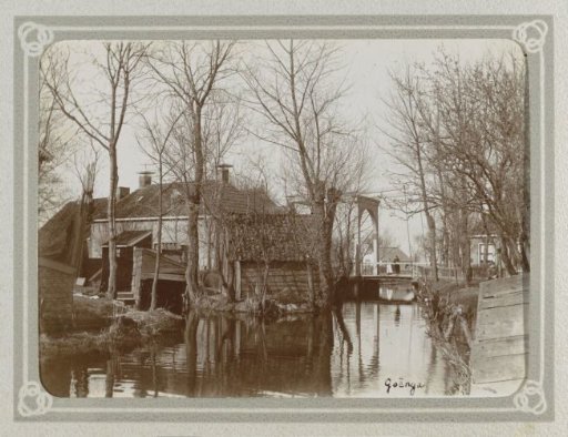 Houses, barns, a bridge with two children, and a ditch in Goënga