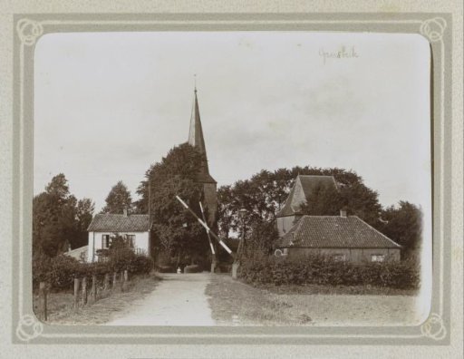 Street in Groesbeek with barriers, church tower and houses