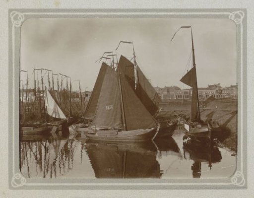 Sailing ships in a harbor, with the UK76 from Urk in the foreground