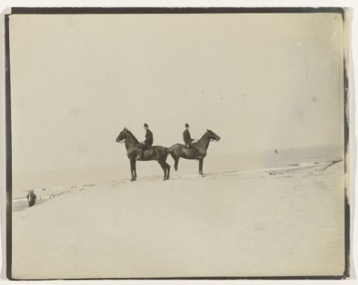 Two men (military?) on horseback on a dune, Netherlands, with the sea in the background