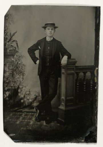 Portrait of a young man, standing by a balustrade before a painted backdrop