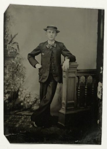 Portrait of a young man, standing by a balustrade before a painted backdrop