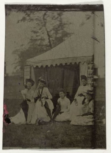 Group portrait of five women in front of a ferrotype tent in the open air