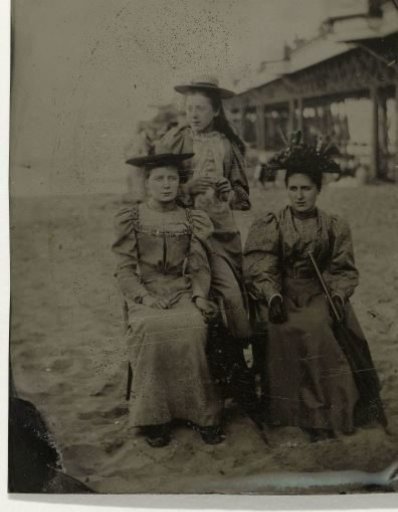 Three Women on the Beach, with a Pier in the Background