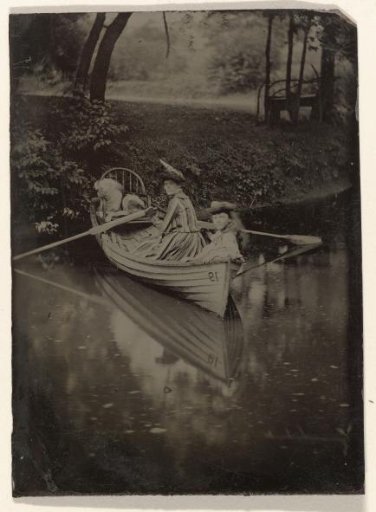 Two Women and a Dog in a Rowboat at the Edge of a Lake