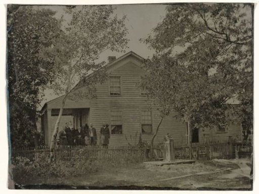 Inhabitants in front of a wooden house