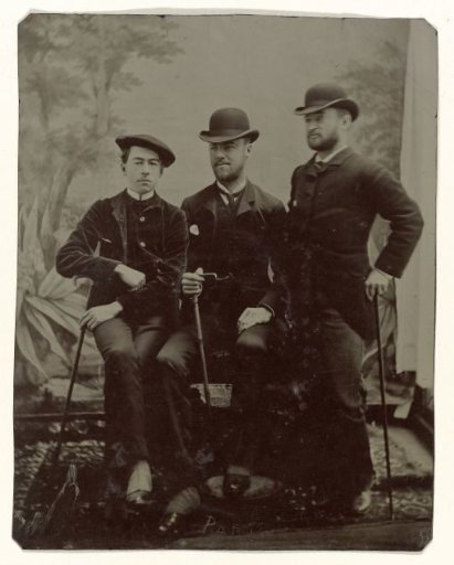 Portrait of three men in front of a backdrop painted with a forest scene