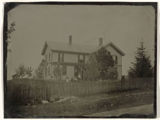 View of a wooden house with the inhabitants in front