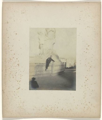 Tony Artz seated on the pedestal of a sculpture on the grounds of the World's Fair in St. Louis (Louisiana Purchase Exposition), 1904