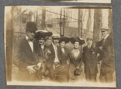 Four young women and four men in a forest, the man on the left holding a camera