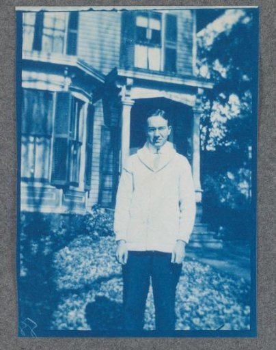 Young man in front of a dwelling, probably a student residence on the campus of St. Johnsbury Academy in Vermont