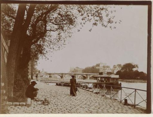 Woman walking along the Seine, man sitting next to a tree, Paris