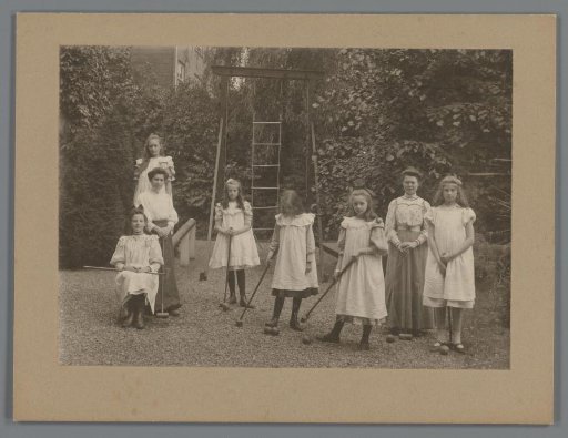Group portrait of Johanna (Hans) de Jong with girls and women holding croquet mallets in a garden