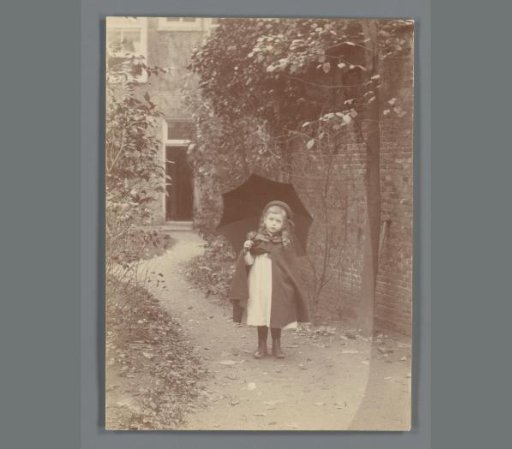Portrait of Johanna (Hans) de Jong with umbrella in the garden of Noordeinde 46 in Leiden