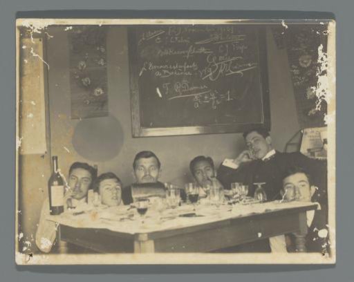Portrait of Frédéric Dumas and his Delft fellow students, smoking around a table with empty glasses and a wine bottle, with a blackboard bearing names behind them