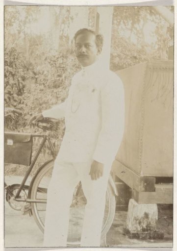 Portrait of headmaster and amateur photographer Paul A.W. de Hart with a bicycle in Paramaribo