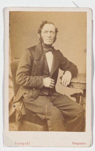Portrait of a seated man in a coat
