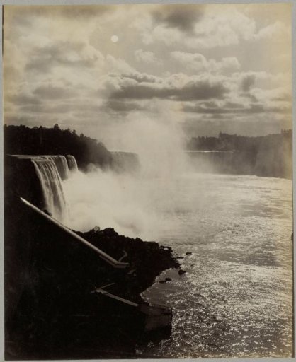 View of Niagara Falls by full moon with a pier in the foreground