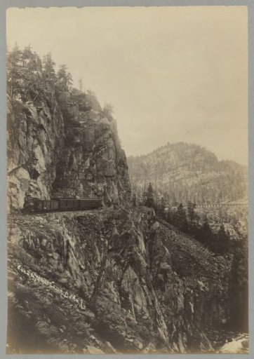Train of the D.&R.G.Ry in the Animas Canyon in Colorado with a railway viaduct on the right