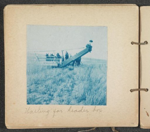 Farmers at a reaping machine, waiting for a cart
