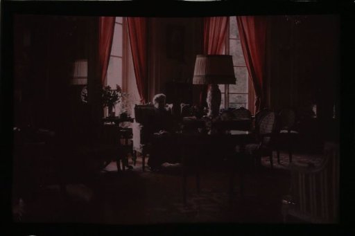 Interior, with a lady seated in an armchair