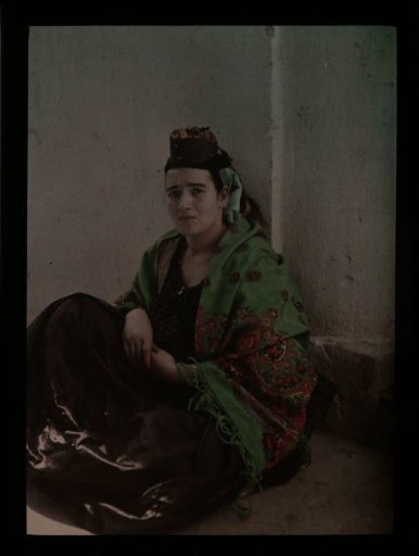 Woman dressed in Oriental attire, seated on her haunches