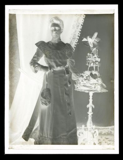 Portrait of an Unknown Woman Next to a Side Table with a Flower Arrangement