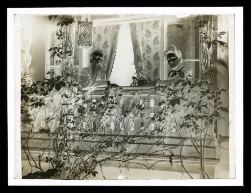 Man and Woman on a Balcony, Seen Through Shrub Leaves