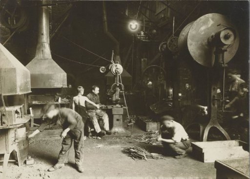 Workers in a metalworking shop, including three children