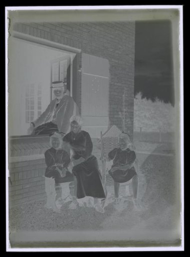 Portrait of Elsa Diepenbrock seated with daughters Thea and Joanna and Alphons Diepenbrock in the window frame of house 'Holtwick' at Laren