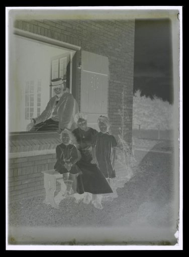 Portrait of Elsa Diepenbrock seated with daughters Thea and Joanna and Alphons Diepenbrock in the window frame of house 'Holtwick' at Laren