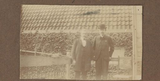 Two standing men in a garden