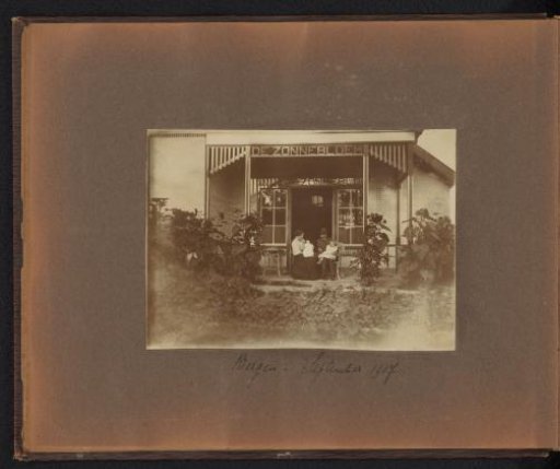 Page from the Diepenbrock family photo album with a photograph of a woman and a man each with a child on their lap on the veranda of De Zonnebloem in Bergen (NH)
