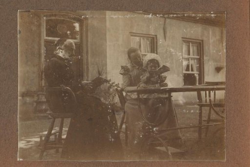 Two women with a child at a table outdoors