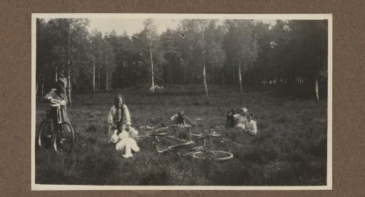 Four People with Bicycles in a Field