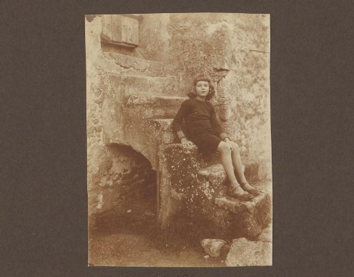 Portrait of a girl seated on a stone outdoor staircase, possibly Thea Diepenbrock