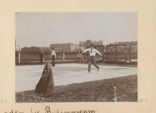 Two men playing tennis on the court behind the Rijksmuseum