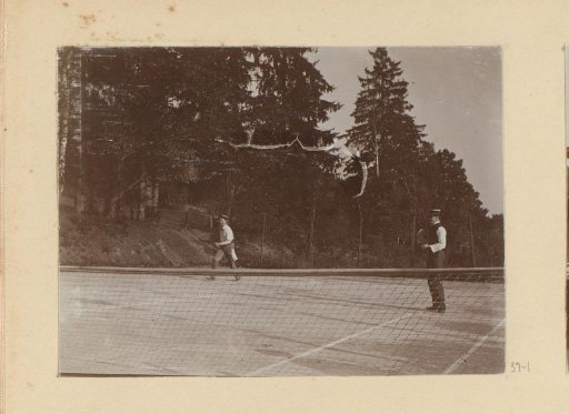 Two men playing doubles on a tennis court
