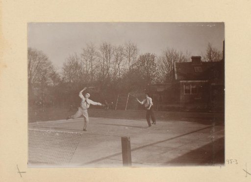 Two Men Playing Doubles on a Tennis Court