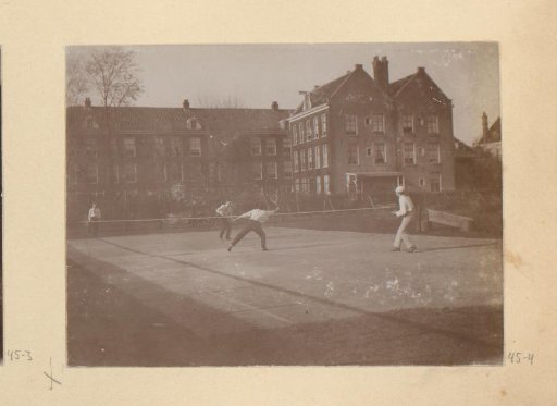 Four people playing doubles on a tennis court