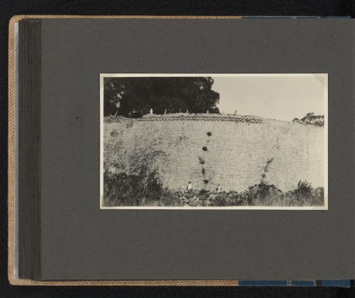 Two women against a high stone wall