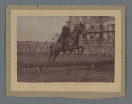 Henk van de Berg on his horse Bobbie jumping a hurdle in the field behind the Rijksmuseum