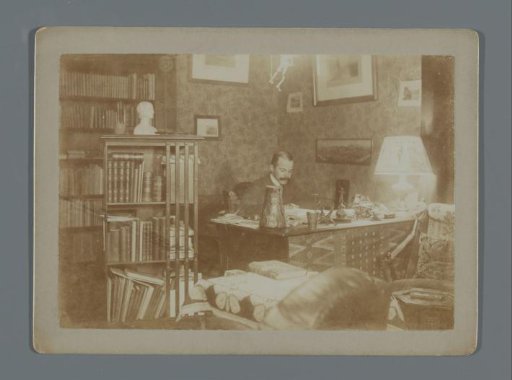Henk van de Berg behind his desk in his room at Turfmarkt 3 in Amsterdam