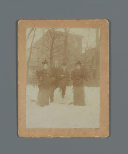 Group in the snow before the fence of an unknown building