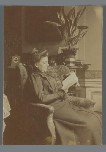 Pauline van den Berg reading in an armchair