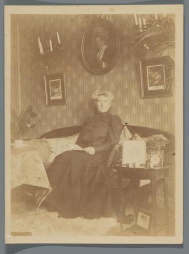 Delle Wichers seated on a bench in an interior