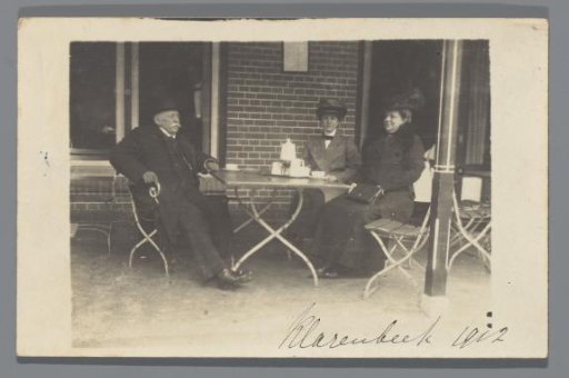 Norbert van den Berg with two women at a table on a terrace