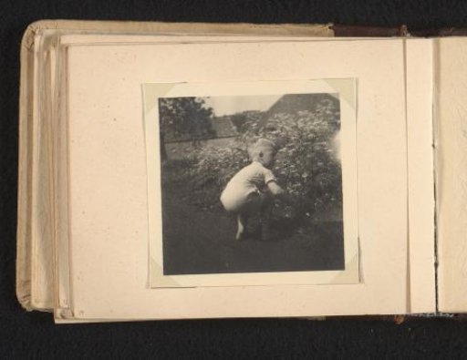 Norbert Peter van den Berg as a toddler crouching by a flower bed