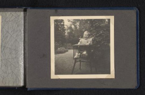 Norbert Peter van den Berg as a baby in a high chair in a garden